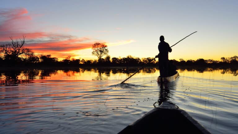 Traditional mokoro safari at sunset in the Okavango Delta